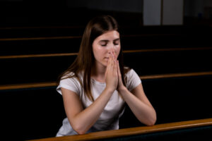christian-girl-white-shirt-is-sitting-praying-with-humble-heart-church_7280-2043
