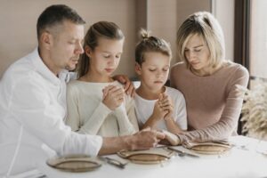 family-praying-together-before-eating_23-2148769380